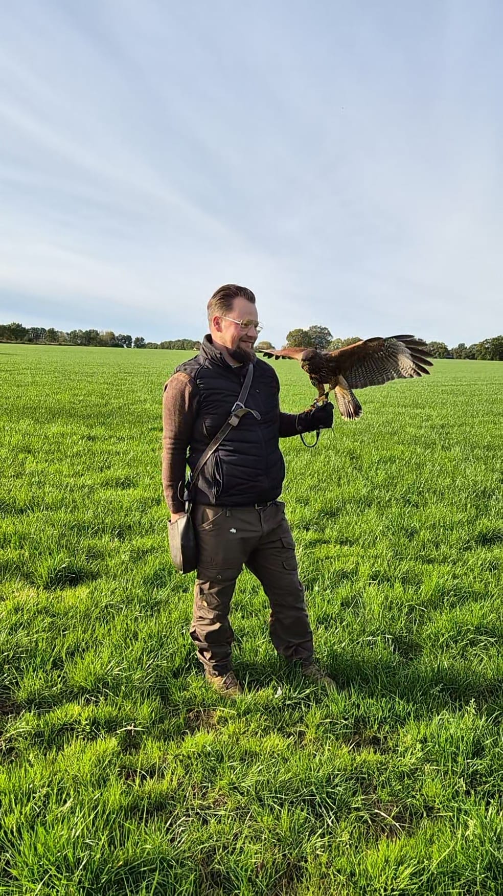 Valkenier met getrainde roofvogel in Nederlands landschap